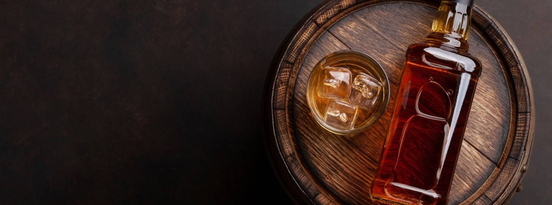 Celtic Renewable transforme les déchets organiques de whisky en carburant biosourcés. Bouteille de whiskey écossais, verre et vieux baril