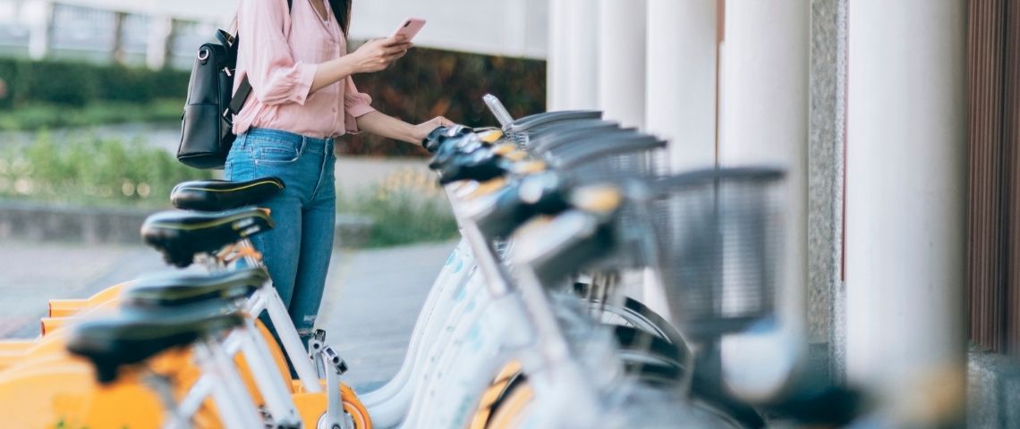 Cooltra lance le premier libre-service privatif de deux-roues dédiée aux entreprises Une femme loue un vélo.