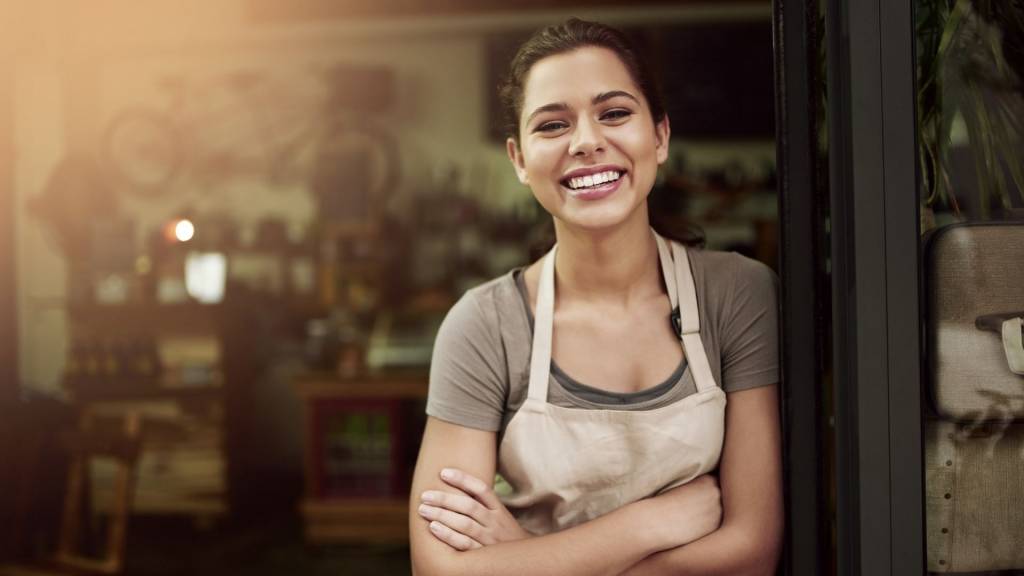 Commerçante souriante devant sa boutique