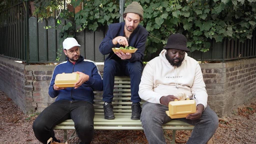 Roman Frayssinet, Djimo et Hakim Jemili assis sur un banc en train de manger