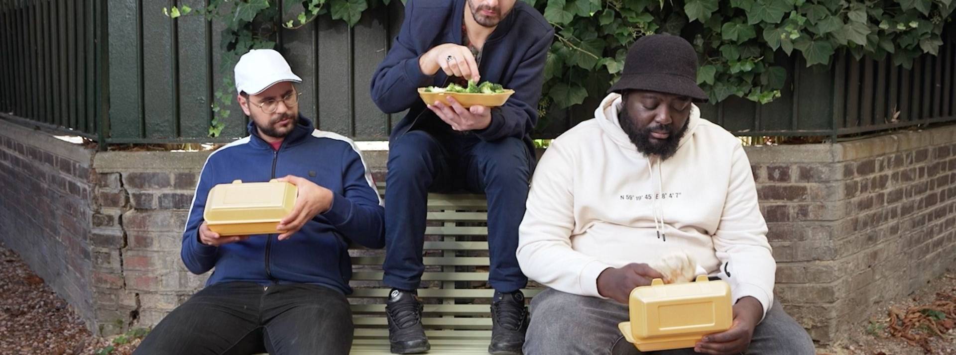 Santé publique France et son agence Romance lancent le deuxième opus du programme « En 2-2 », visant à encourager les jeunes à mieux manger Roman Frayssinet, Djimo et Hakim Jemili assis sur un banc en train de manger