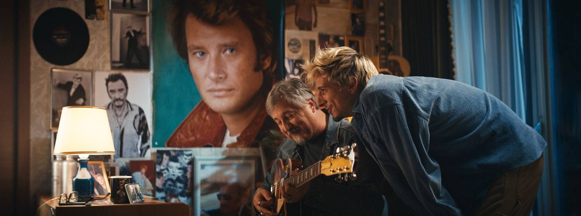 Cette année, Bouygues Telecom a voulu rendre un vibrant hommage à Johnny Hallyday pour sa campagne de Noël 2 hommes, l'un jouant de la guitare, l'autre penché vers lui avec des posters de Johnny Hallyday en arrière plan