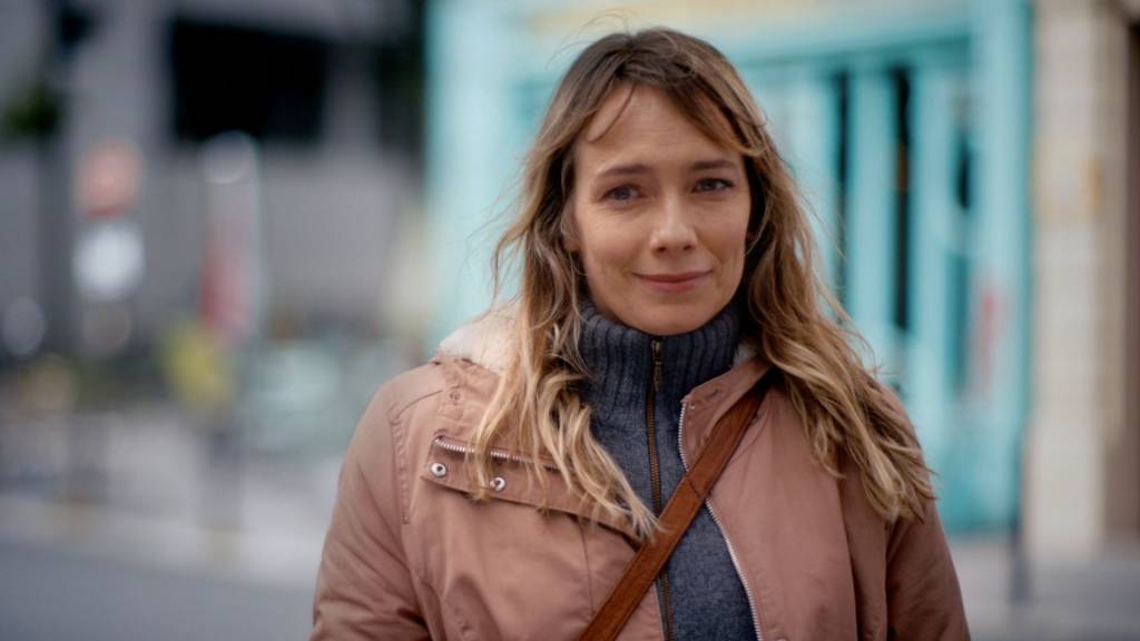 La campagne Fondation Abbé Pierre est signée FRED & FARID Paris Femme souriante se promenant dan la rue