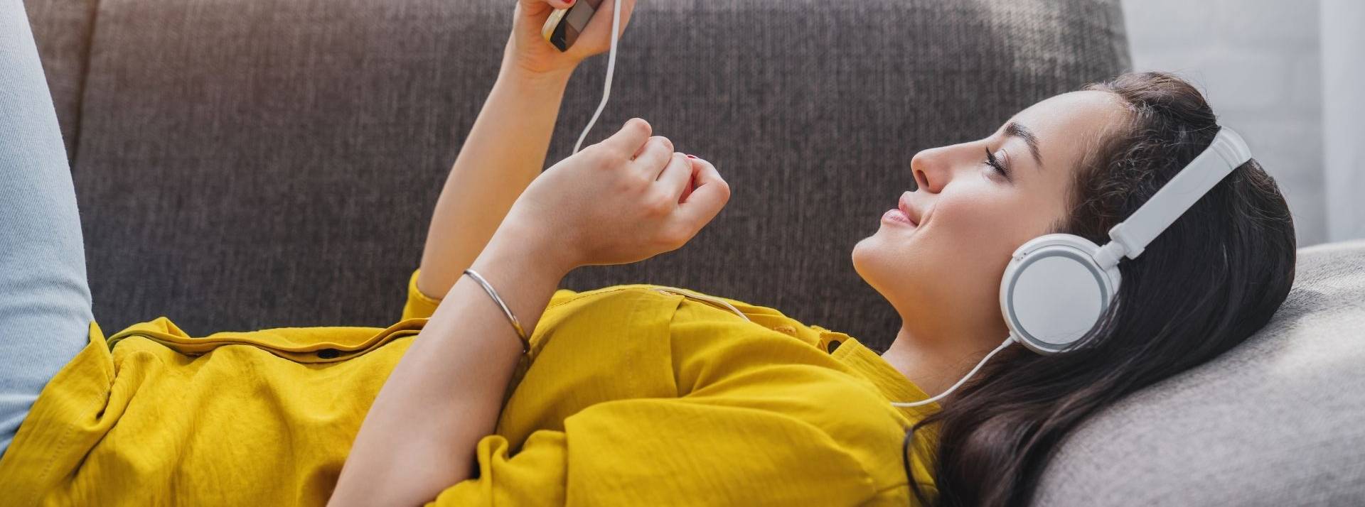 Clubhouse désormais disponible en francais active les replay jeune femme écoutant la musique en ligne sur le smartphone dans le casque