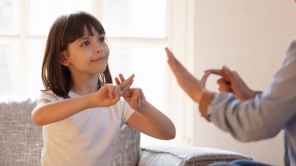 Petite fille pratiquant le langage des signes.