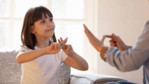 Petite fille pratiquant le langage des signes.
