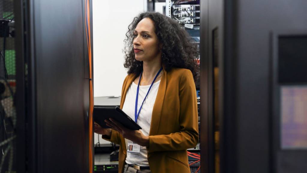Professionnel féminin d’INFORMATIQUE dans la salle de serveur