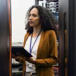 Professionnel féminin d’INFORMATIQUE dans la salle de serveur