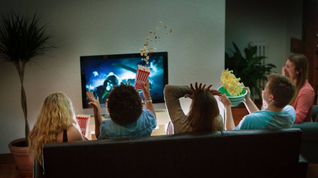 Groupe d'amis en regardant un film Halloween effrayant ensemble à la maison