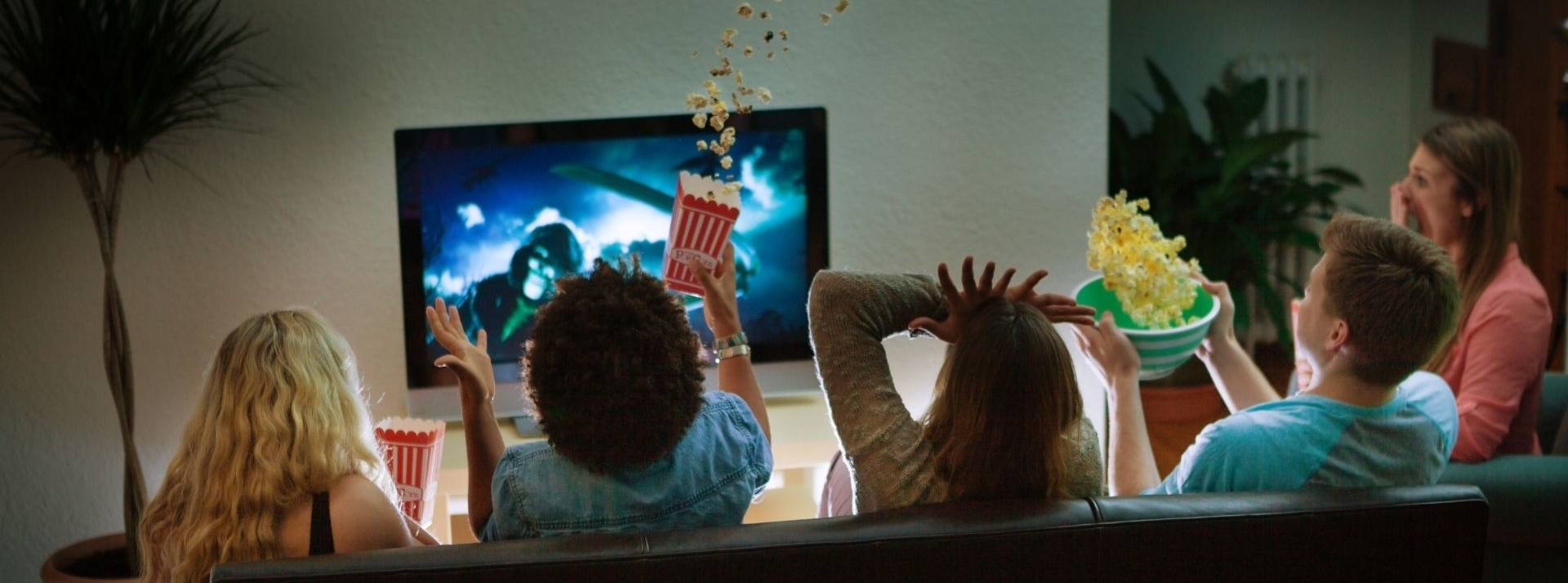 Étude FreeWheel agences et annonceurs : La France championne d’Europe de la publicité Advanced TV en 2022 Groupe d'amis en regardant un film Halloween effrayant ensemble à la maison