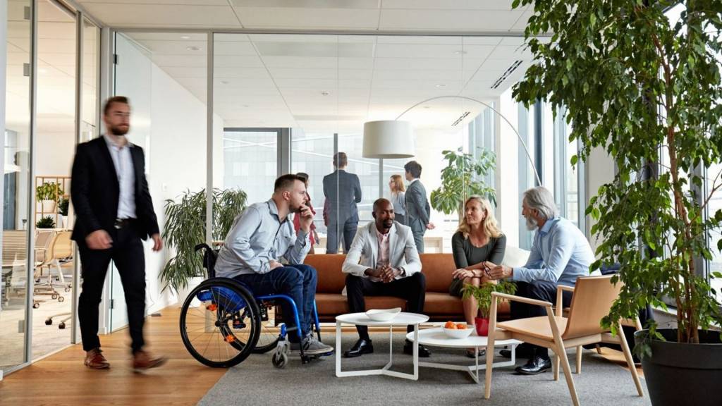 Réunion d’équipe de direction diversifiée dans la salle de réception du bureau