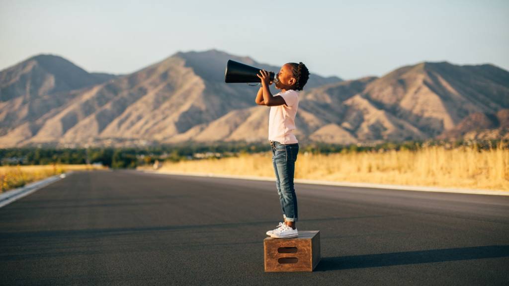 Jeune fille sur une caisse en bois avec un mégaphone