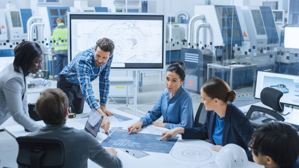 Equipe au travail autour d'une table entourée par des machines