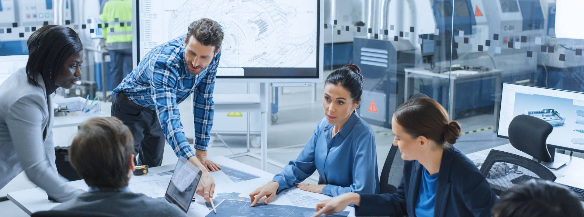 Industrial Tech : Speedinvest et Dealroom publient leur rapport européen 2021 Equipe au travail autour d'une table entourée par des machines