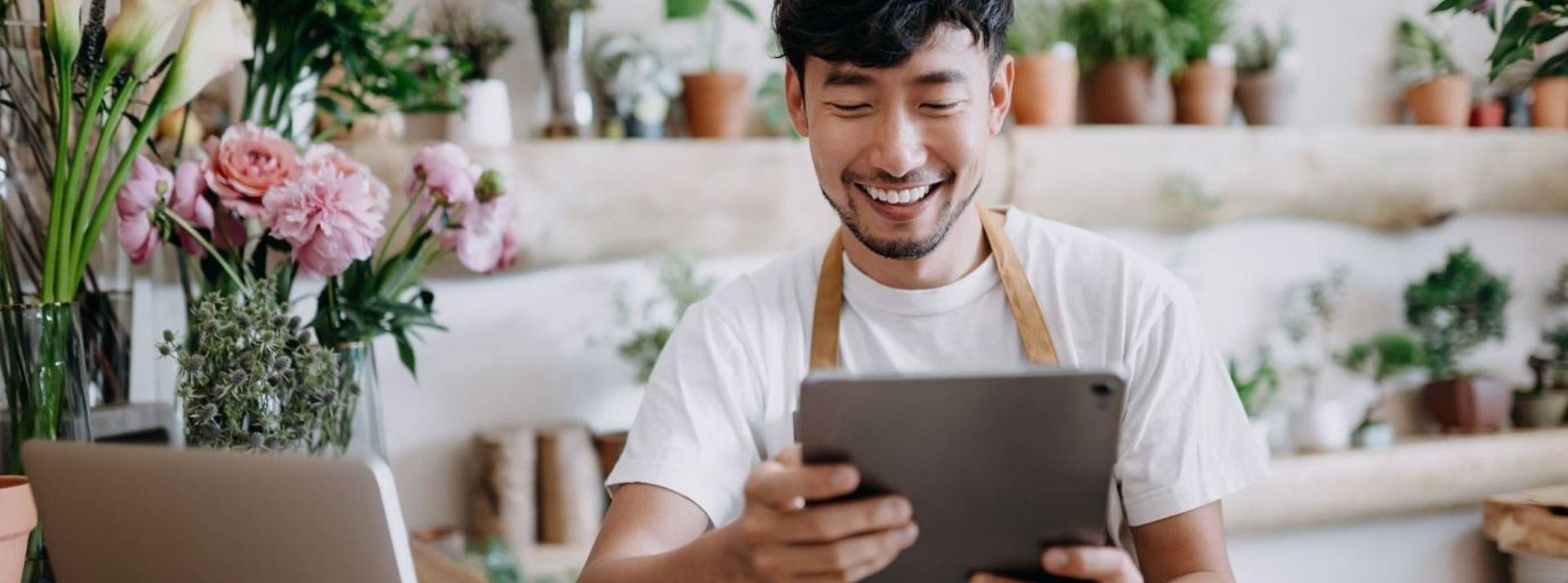 La startup française Kreezalid accompagne les acteurs de l’économie circulaire dans leur transformation Fleuriste dans sa boutique tenant une tablette