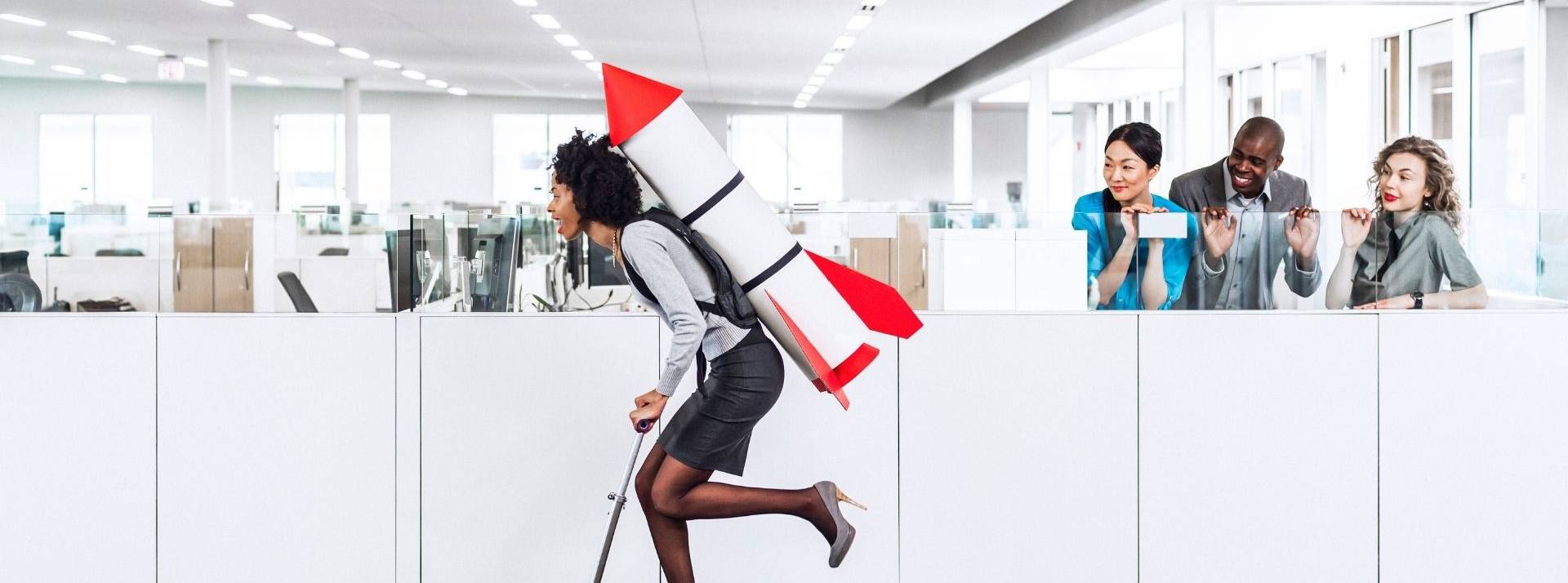 Les Conquérantes, un concept novateur pour propulser l’entrepreneuriat féminin. Femme sur une trotinette avec une fusée dans le dos, roualt dans des bureaux de travail