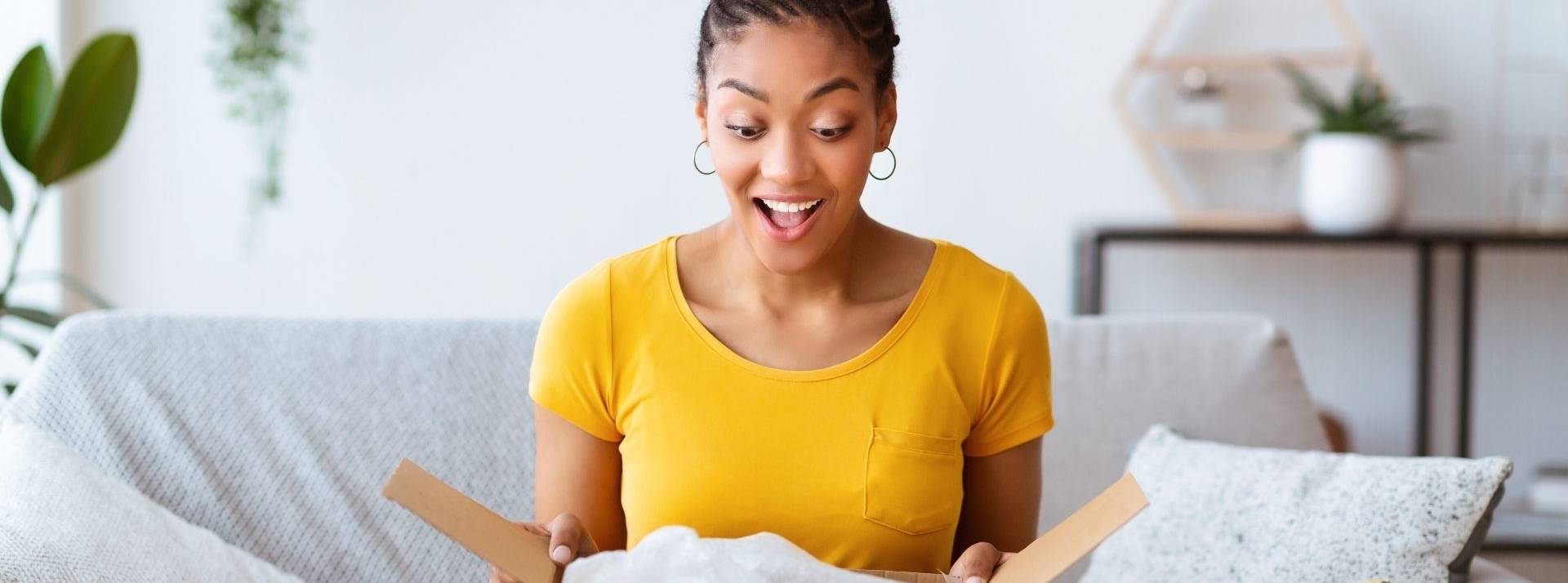 Packhelp lève 40 M€ dans le cadre d'une Série B pour devenir la première place de marché mondiale dans le packaging personnalisé et durable jeune ouvrant un colis en carton