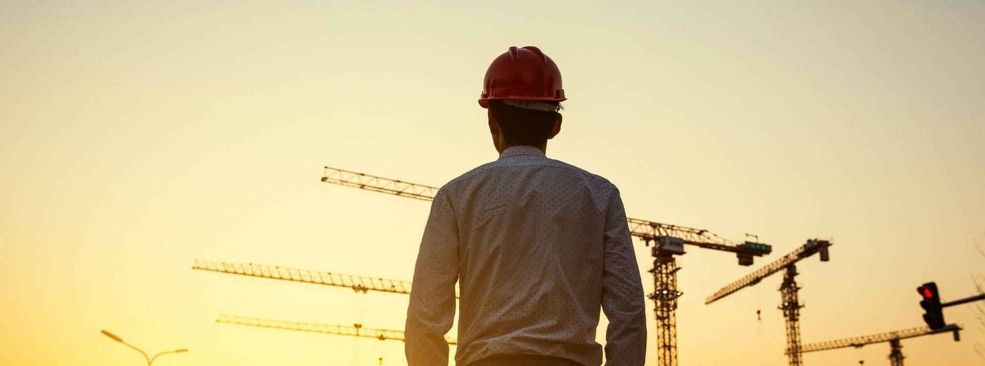 Tribune de Michel Saprannous livre ses pistes pour repenser le secteur du BTP sur le très long terme.ides Homme de dos avec des grues en arrière plan