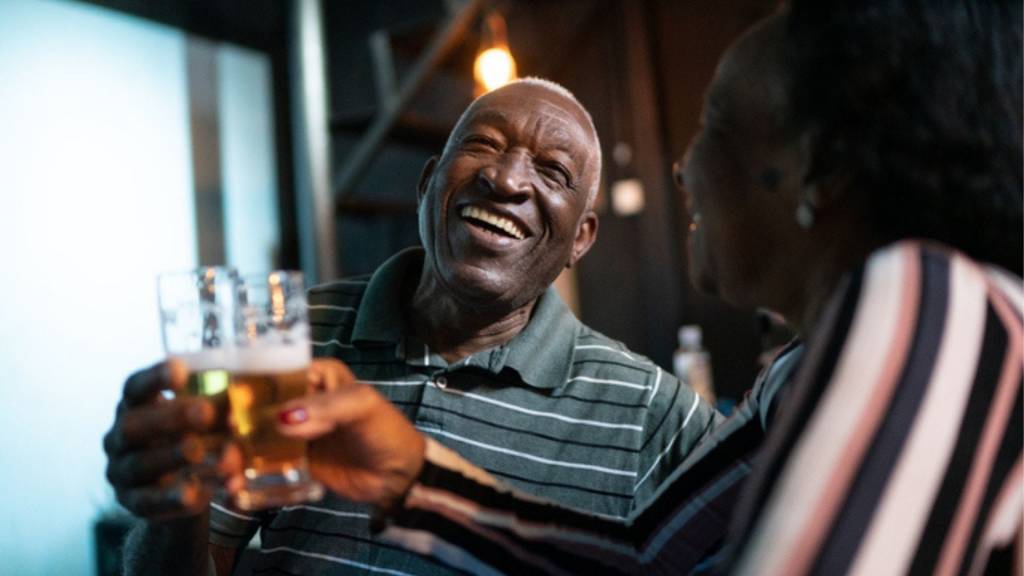 Couple toastant la bière dans un bar.