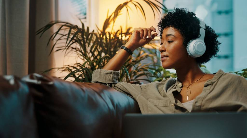 TIDAL lance de nouveaux abonnements et de nouveaux modes de rémunération plus juste pour les artistes. femme écoutant de la musique sur son canapé