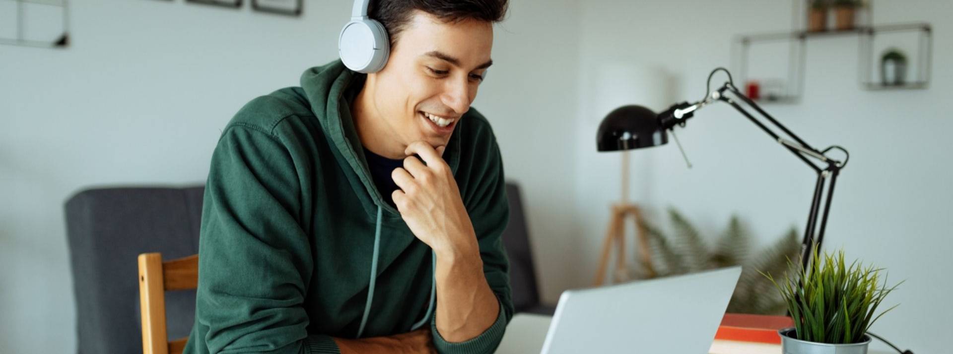 L’apprentissage des langues sur Duolingo : véritable reflet de la société et de l'année 2021 Homme avec un casque sur les oreilles devant un ordinateur portable