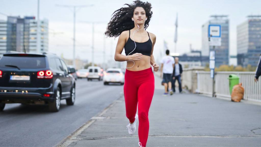 Femme faisant un jogging avec des écouteurs dans les oreilles