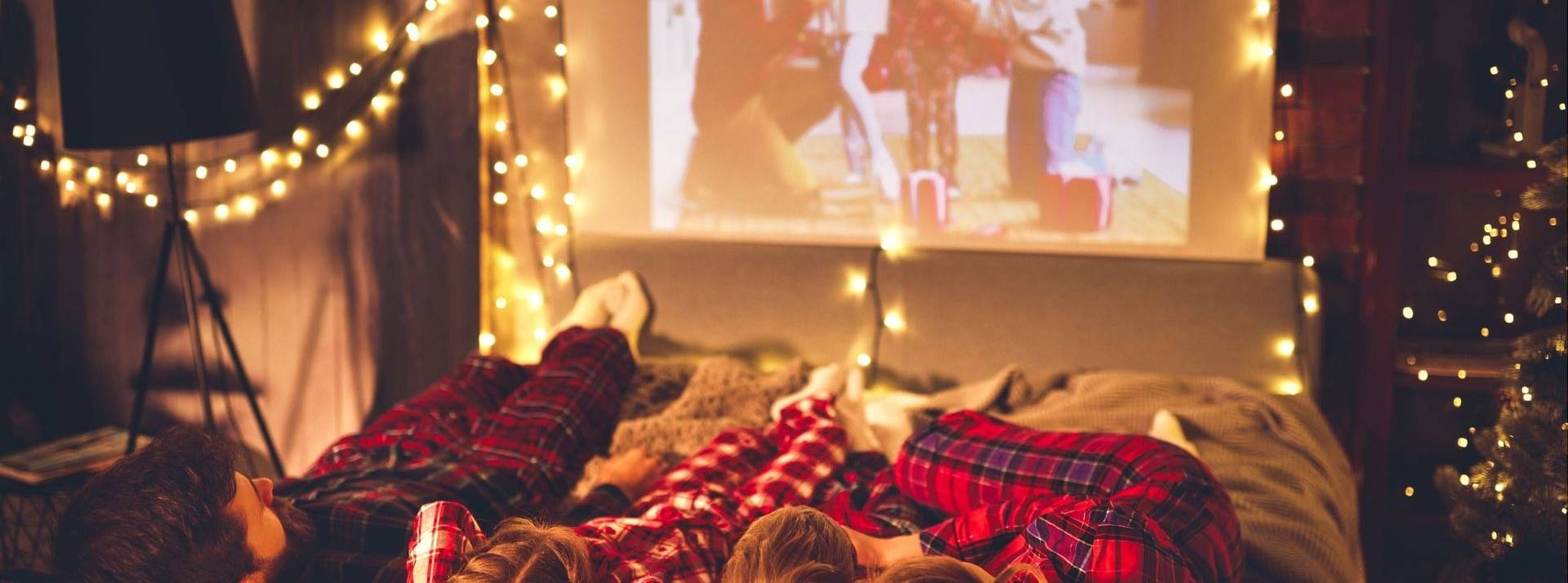 En quoi L’Advanced TV répond aux usages en termes de consommation média ? père de mère de famille et enfants regardant le projecteur, TV, films