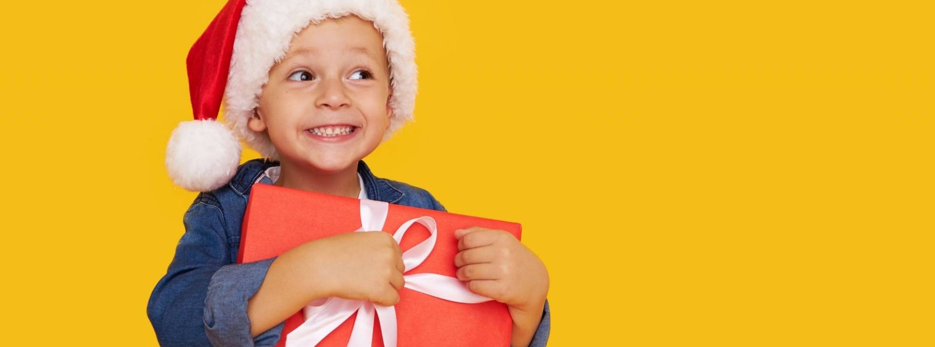 Rakuten France, plateforme e-commerce pionnière sur l’achat-vente de seconde main, dévoile la carte cadeau Vision’R Enfant avec un chapeau de père noel tenant dans ses bras un cadeau