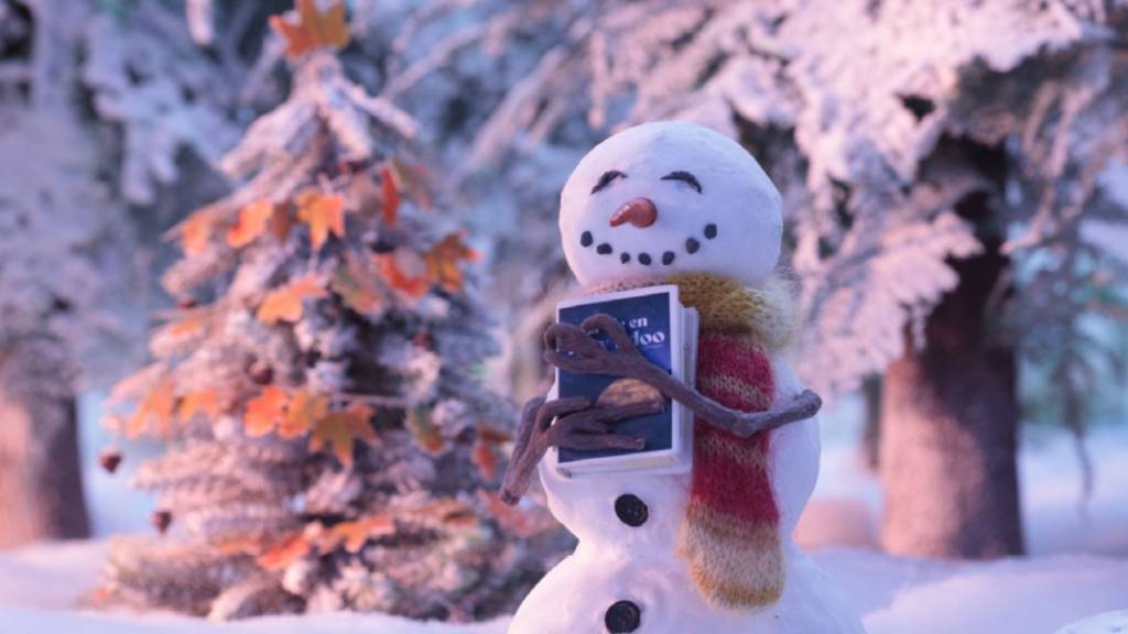 Bonhomme de neige tenant dans ses bras un livre
