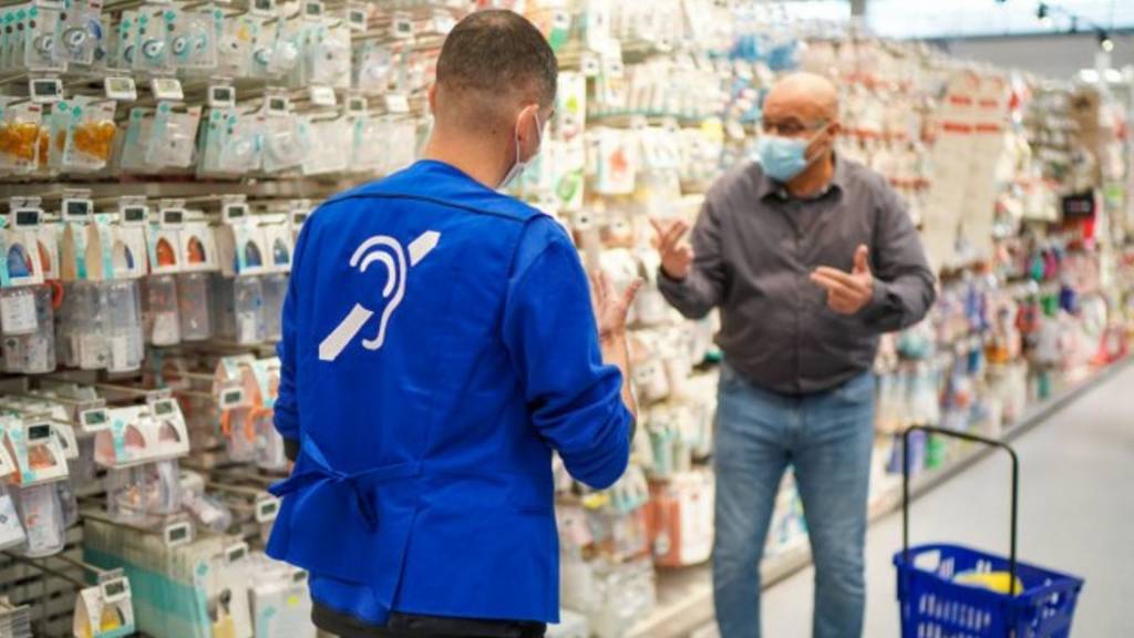 Collaborateurs Carrefour échangeant avec un client en langue des signes