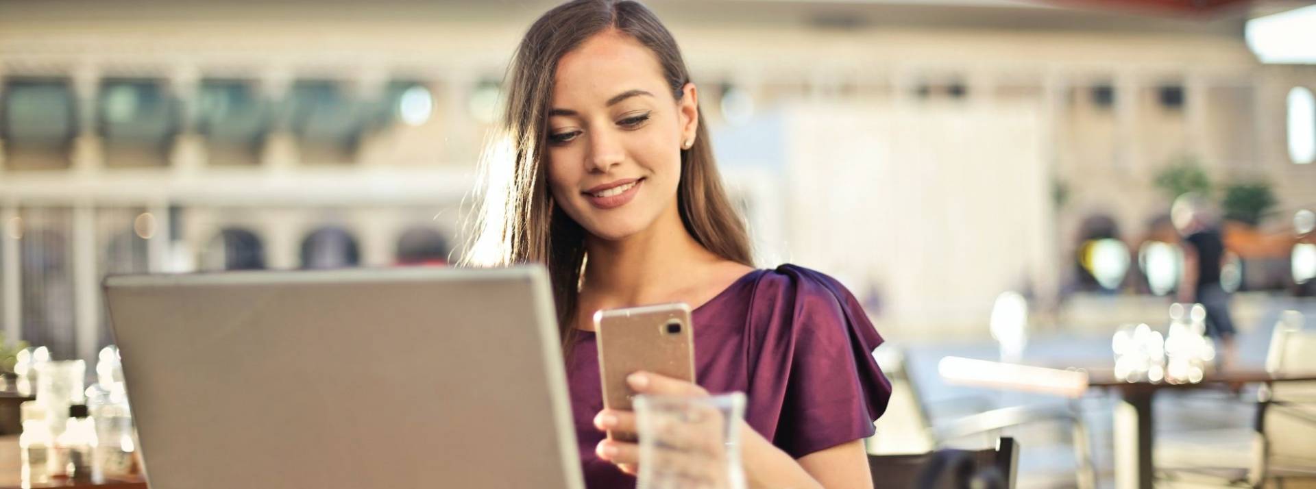 Le CE de la RATP choisit la start-up HappyPal pour distribuer des avantages à ses 100 000 bénéficiaires Jeune femme assise à la table d'un bar consultant son portable