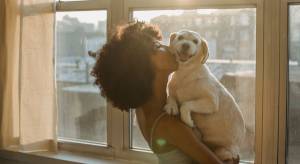 Femme embarssant son chien qu'elle porte dans ses bras