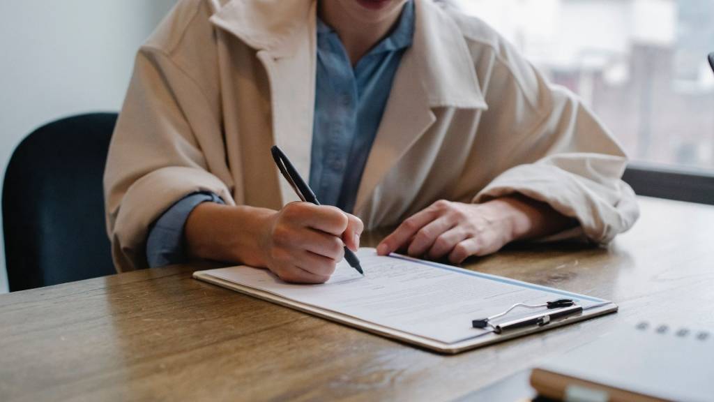 Jeune femme signant en bas d'une page