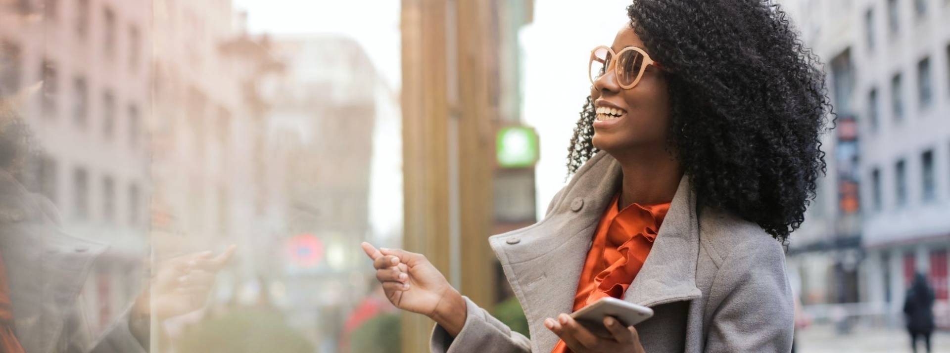 Lagardère Publicité News secoue désormais vos publicités audio, avec son nouveau format « Shake Me »  Jeune femme dans la rue avec un portable à la main