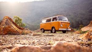 volkswagen combi orange avec la montagen en arrière plan