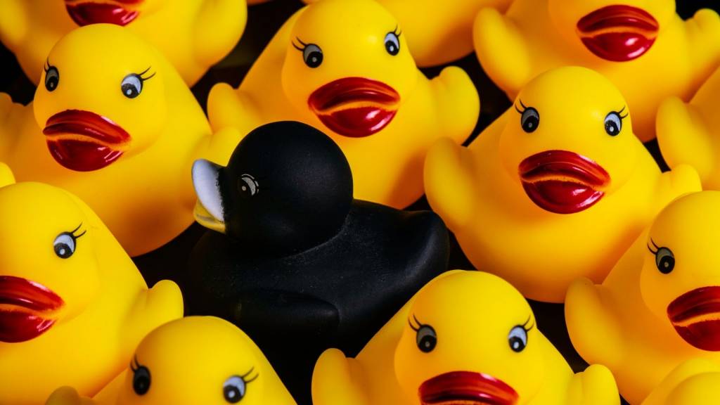 Petits carnards jaunes en plastique avec du rouge à lèvre et un canard noir au centre