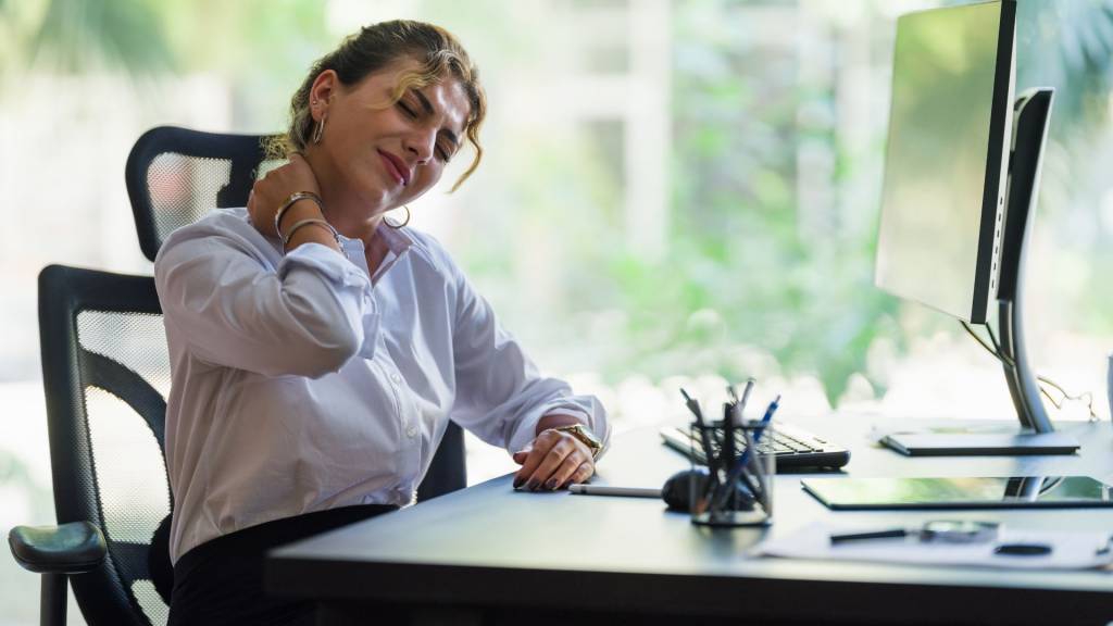 Femme ayant mal au cou en raison d’un travail sur la charge et d’une mauvaise posture