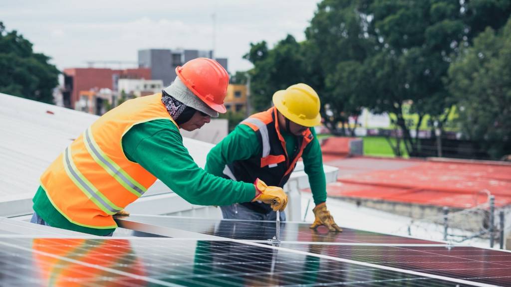 Hommes vissant des panneaux solaires