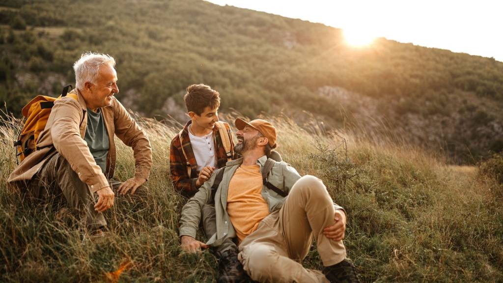 Heureux trois générations mâles se détendre sur la randonnée