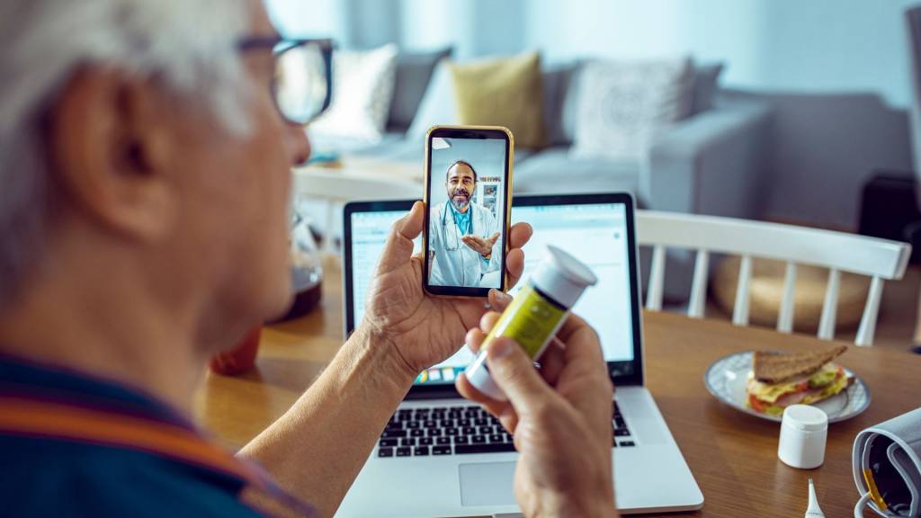 Personne âgée echangeant avec un pharmacien depuis son smartphone