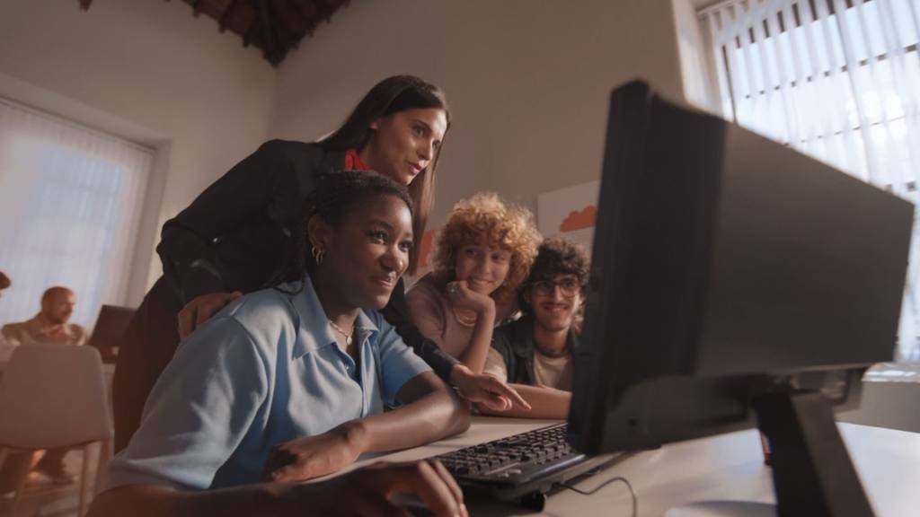 Groupe de jeuens devant un écran d'ordinateur