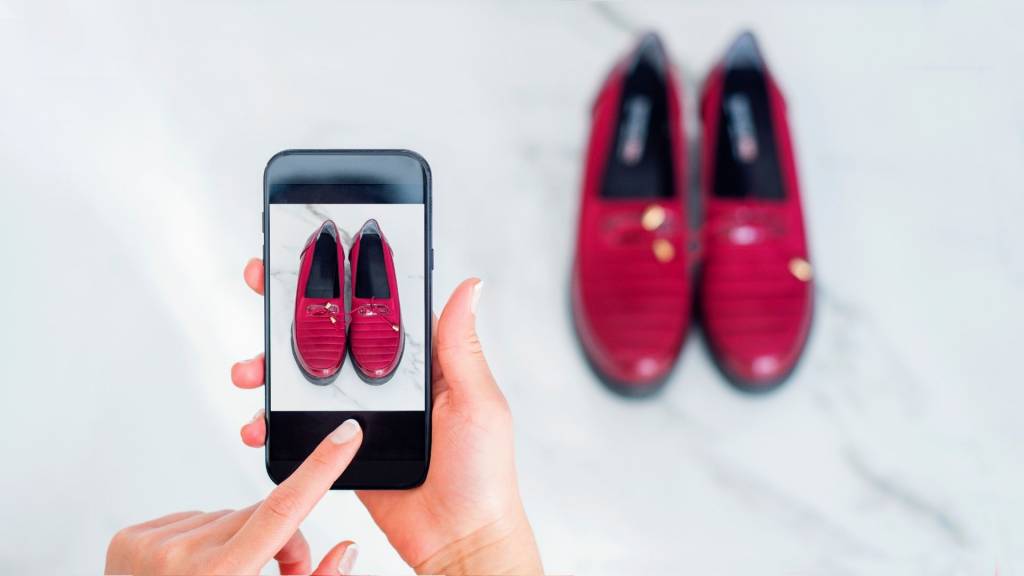 Personne prenant en photo avec son smartphone une paire de chaussures