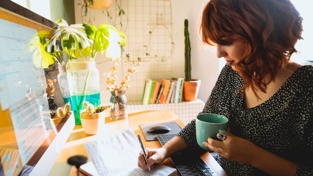Jeunes femme travaillant une tasse à la main