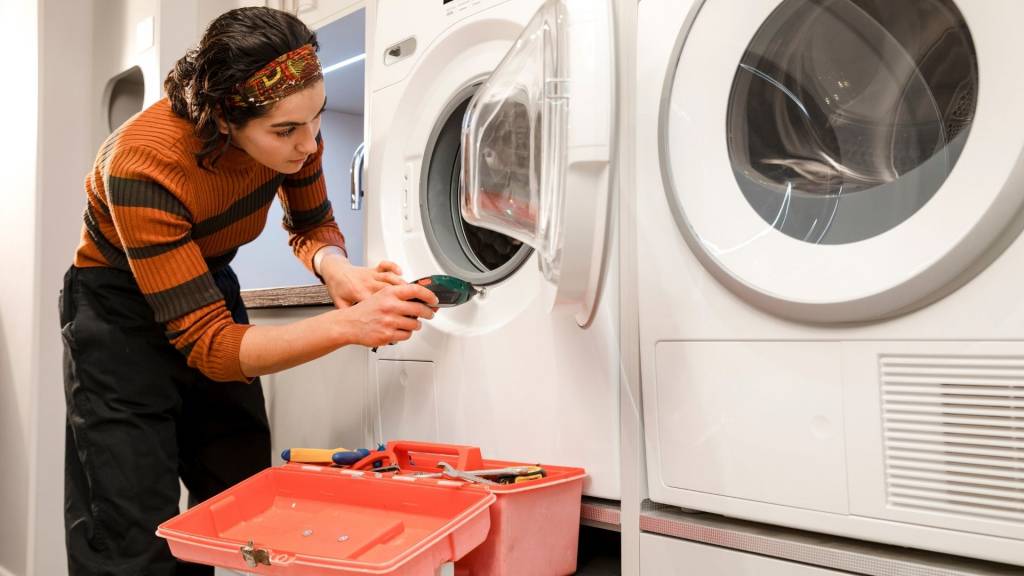 Femme réparant une machine à laver